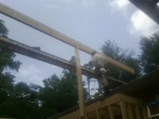Carpenter setting a ridge beam over a new addition frame — Ice Dam Removal by Roofing Brothers in Lake Delton