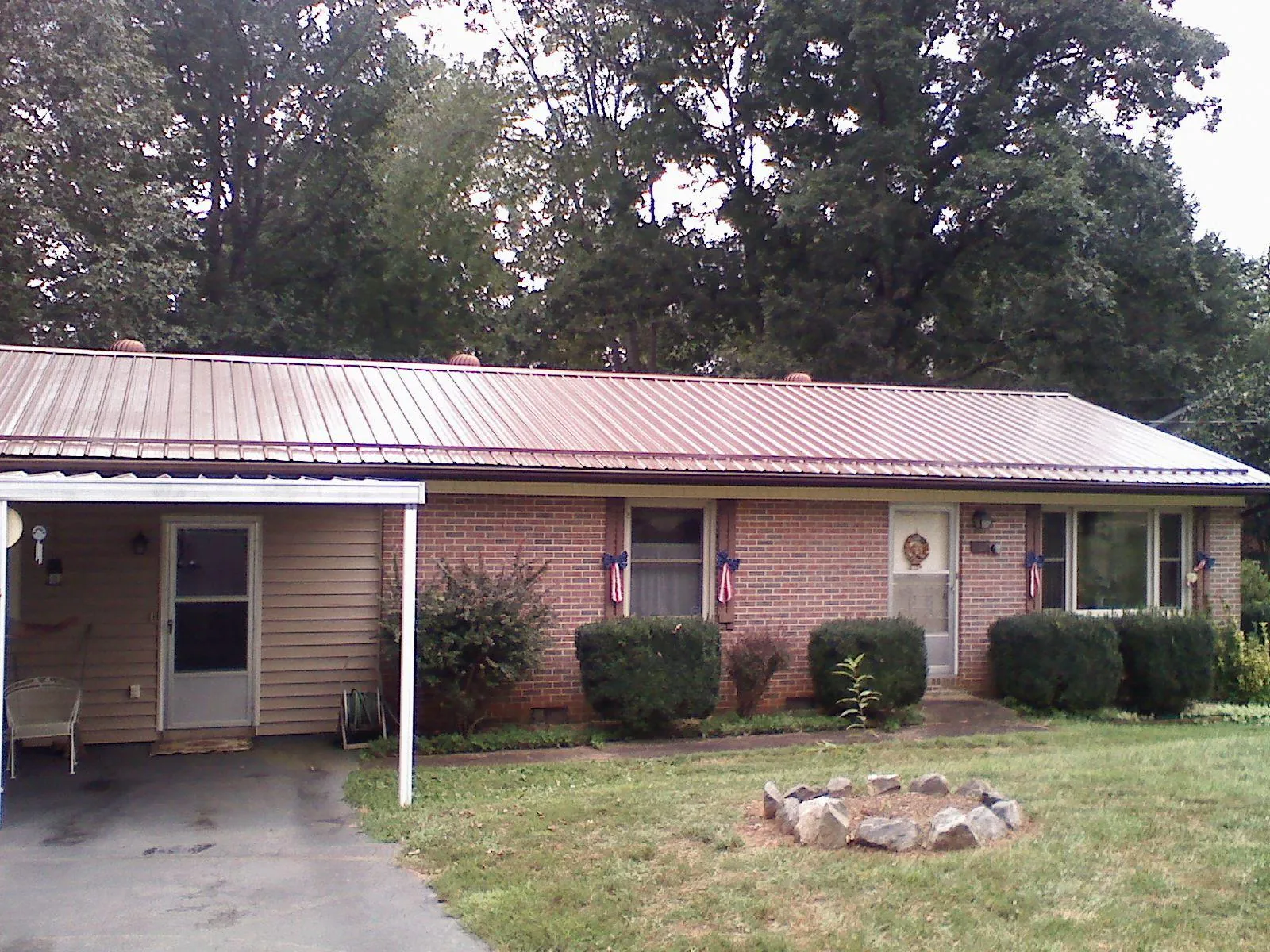 Bronze metal roof and carport on a brick ranch home — Roof Repair work by our crew in Lake Delton