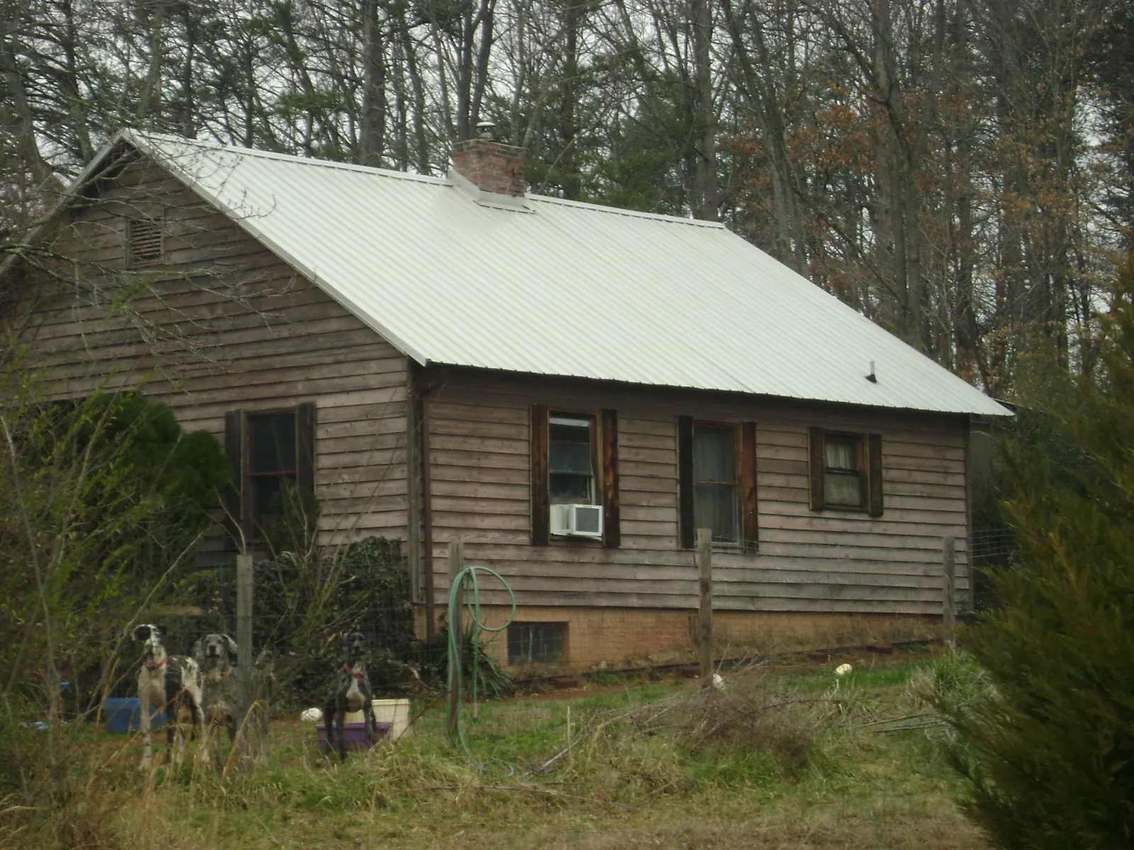 White metal roof on an old wood sided farmhouse, from a Metal Roof Installation job in Lake Delton